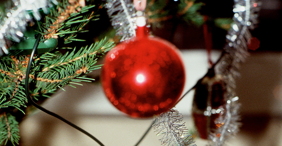 En julgran är pyntad med julkulor och glitter. 